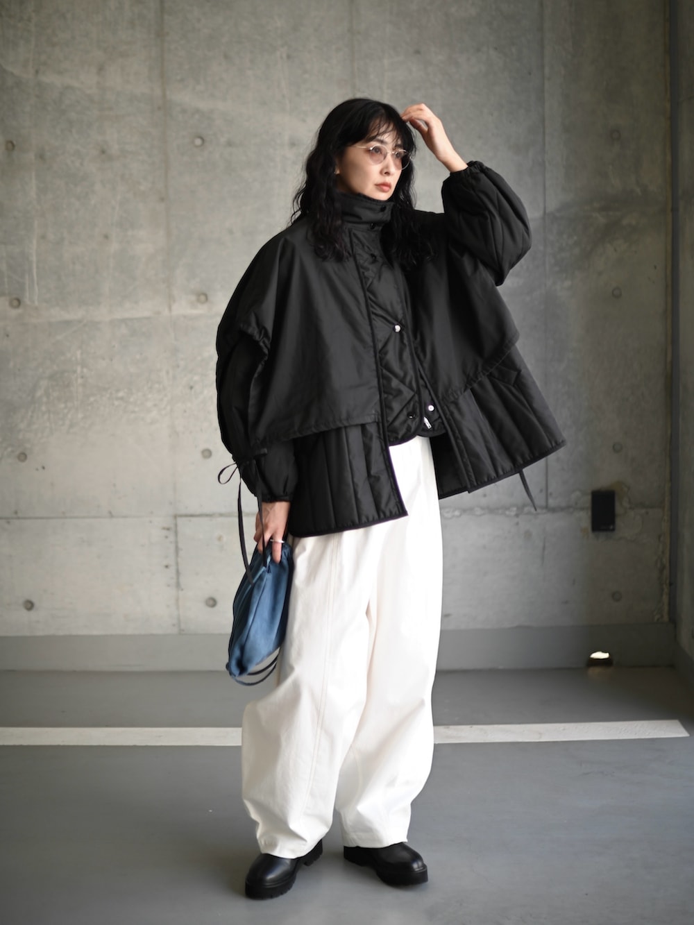 ブラック系のダウンジャケット/コート、ホワイト系のその他パンツ、ブラック系のブーツを着用したレディースの秋コーディネートの4枚目の写真