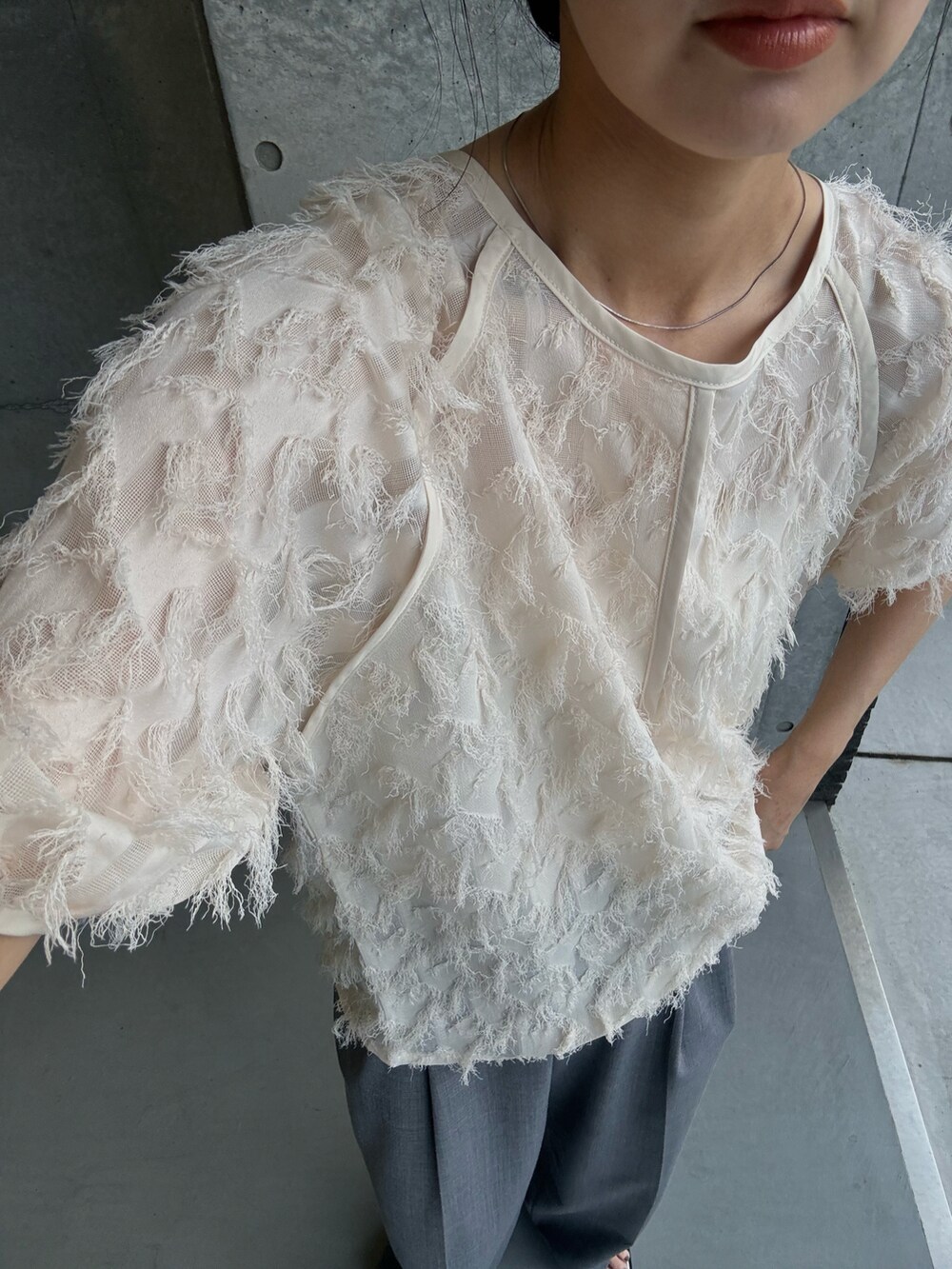 ホワイト系のシャツ/ブラウス、シルバー系のサンダル、グレー系のスラックスを着用したレディースの夏コーディネートの3枚目の写真