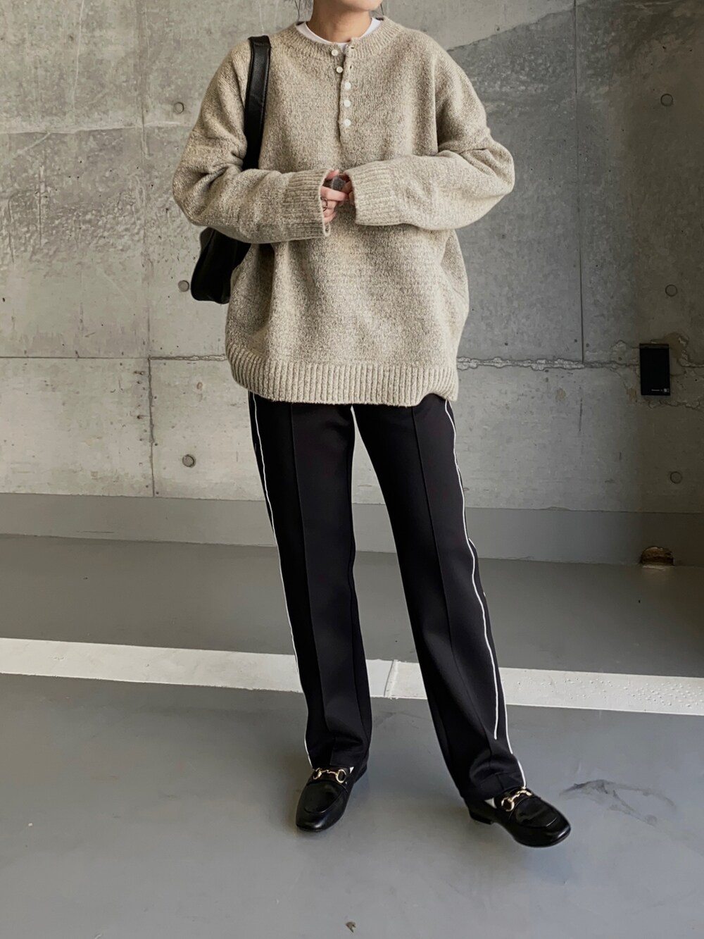 グレー系のニット/セーター、ブラック系のその他パンツ、ブラック系のローファーを着用したレディースの冬コーディネートの2枚目の写真