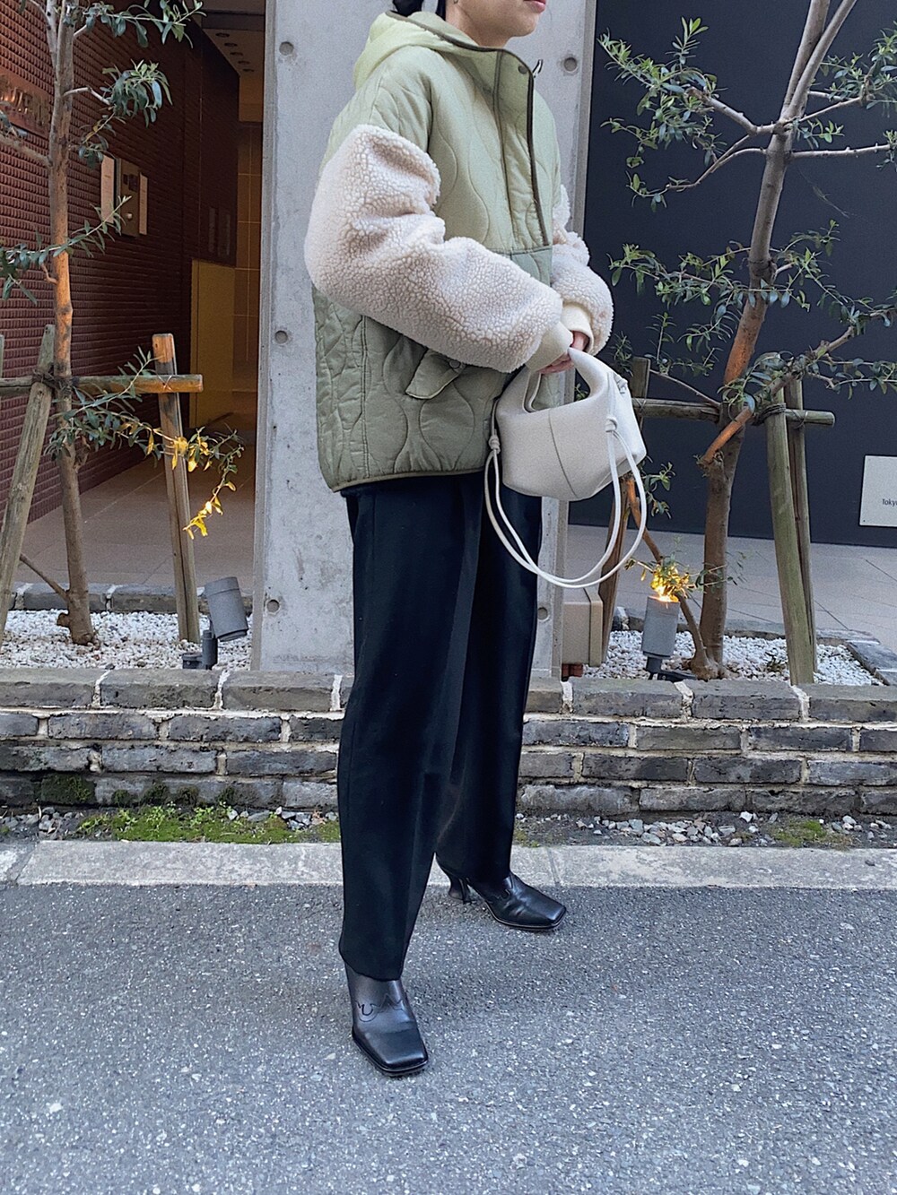 グリーン系のダウンジャケット/コート、ホワイト系のショルダーバッグ、ブラック系のブーツを着用したレディースの冬コーディネートの3枚目の写真