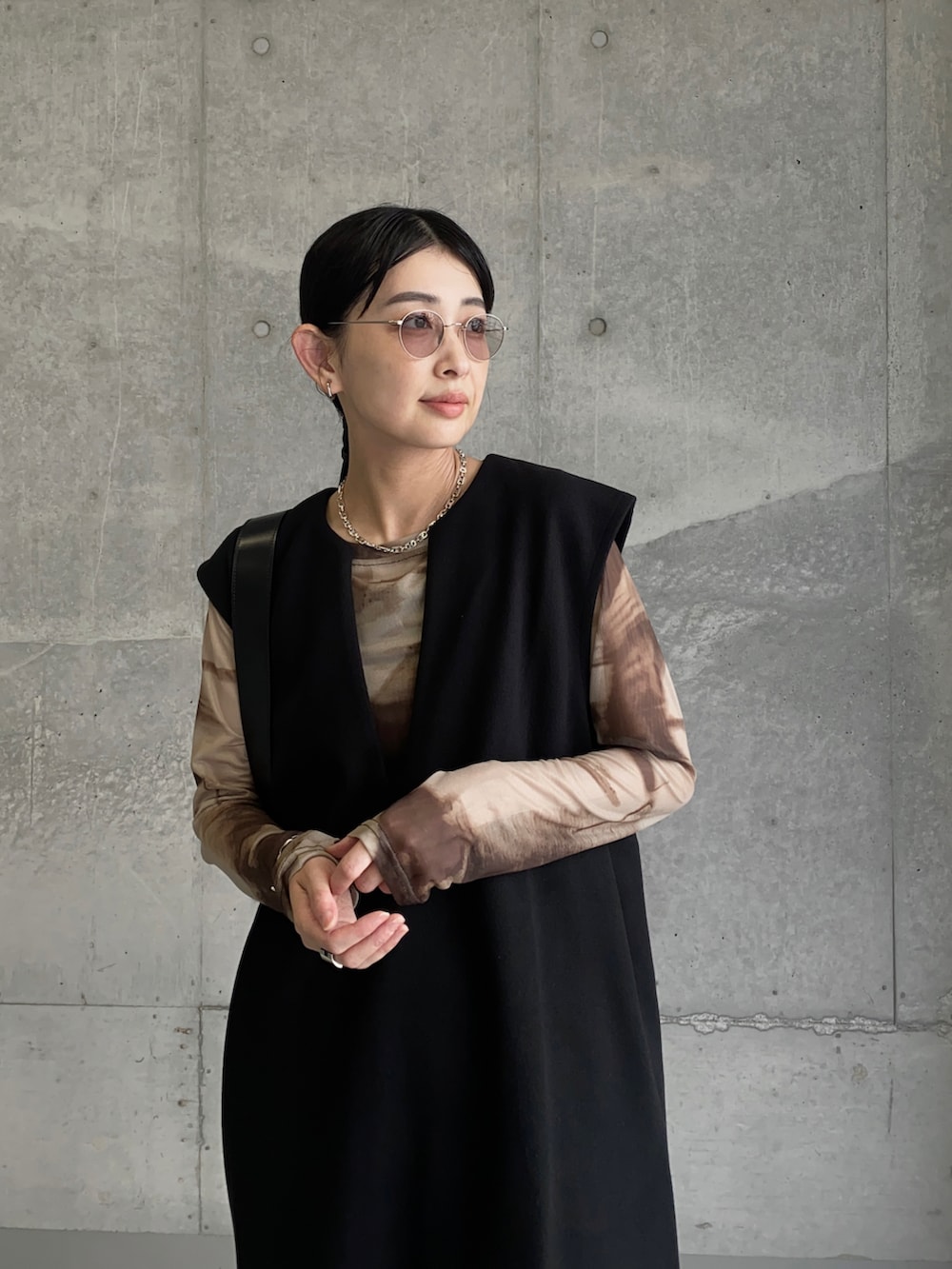 ブラウン系のTシャツ/カットソー、ブラック系のワンピース、ブラック系のショルダーバッグを着用したレディースの秋コーディネートの5枚目の写真