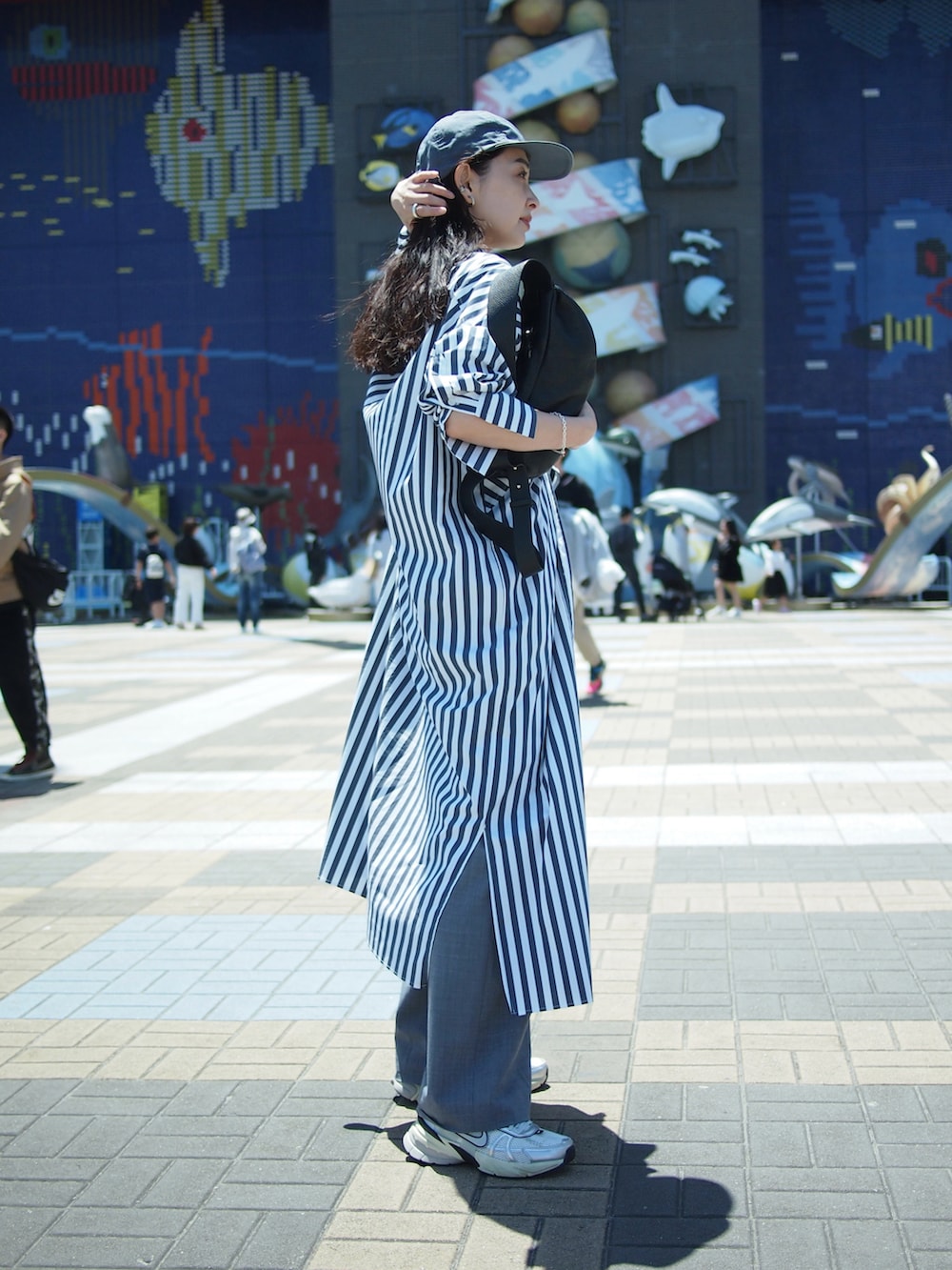 その他のシャツワンピース、グレー系のスラックス、ホワイト系のスニーカーを着用したレディースの春コーディネートの3枚目の写真