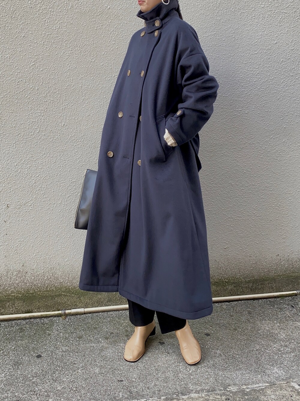 ブルー系のステンカラーコート、ブラック系のメガネを着用したレディースの冬コーディネートの2枚目の写真