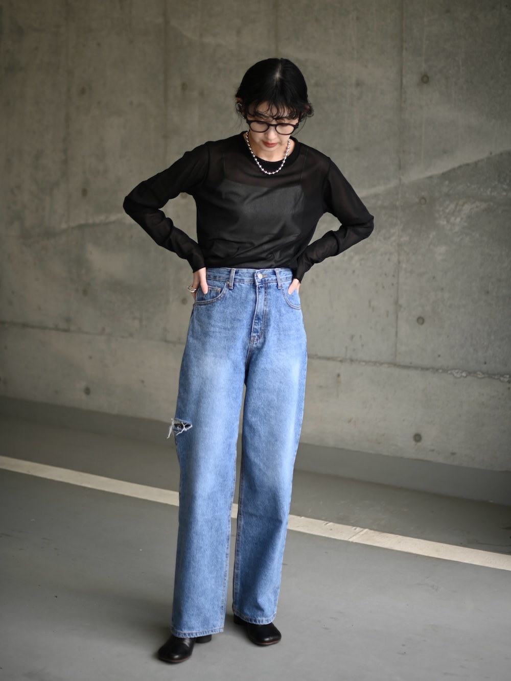 ブラック系のTシャツ/カットソー、ブルー系のデニムパンツ、ブラック系のブーツを着用したレディースの春コーディネートの2枚目の写真