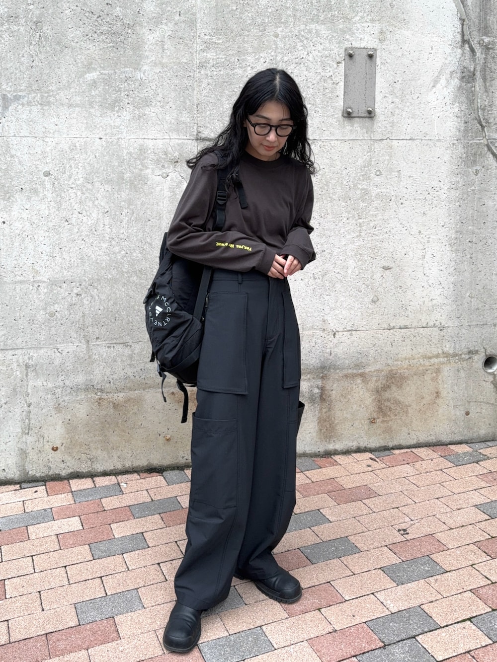 グリーン系のカーゴパンツ、グレー系のTシャツ/カットソー、ブラック系のバックパック/リュックを着用したレディースの秋コーディネートの2枚目の写真