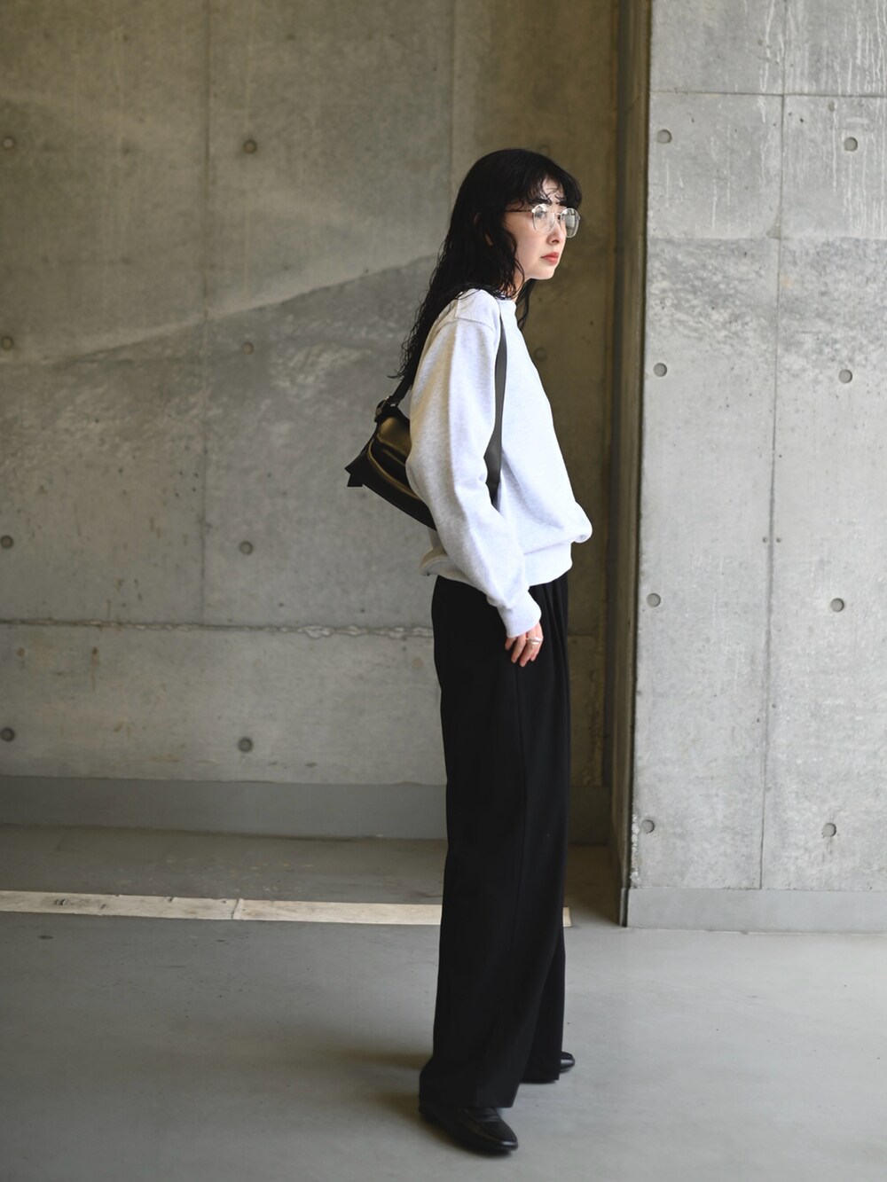 ホワイト系のスウェット、ブラック系のショルダーバッグ、ブラック系のスラックスを着用したレディースの春コーディネートの5枚目の写真
