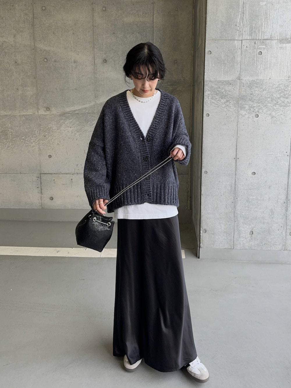 ブルー系のニット/セーター、シルバー系のショルダーバッグ、ブラック系のスカートを着用したレディースの冬コーディネートの2枚目の写真