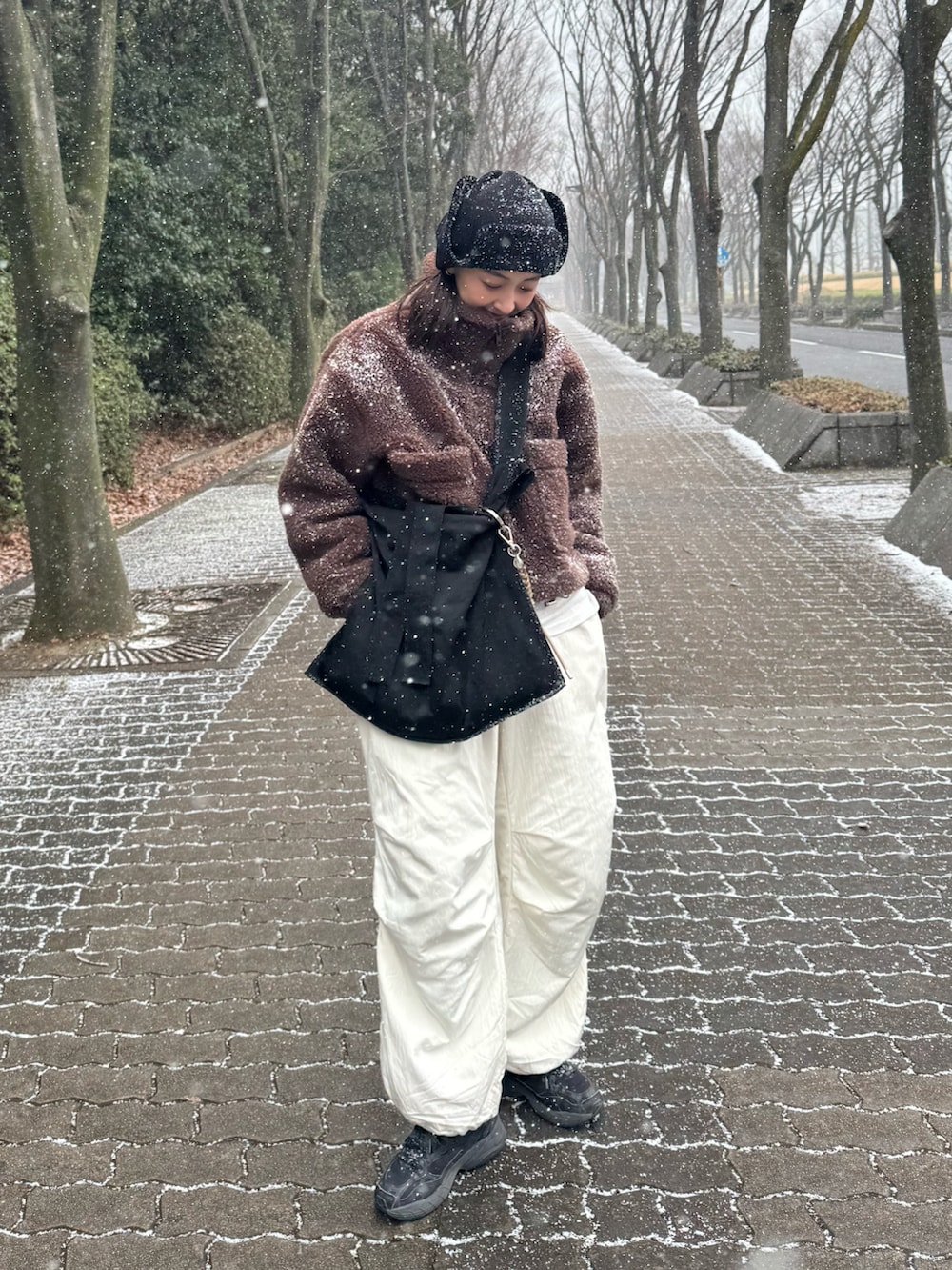 ブラウン系のその他アウター、ブラック系のトートバッグ、ホワイト系のその他パンツを着用したレディースの冬コーディネートの2枚目の写真