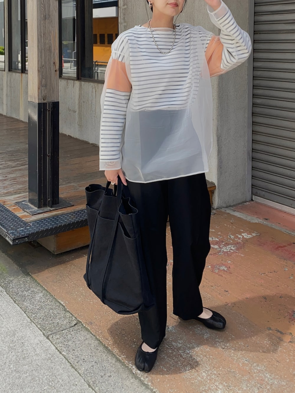 オレンジ系のTシャツ/カットソー、ブラック系のその他パンツ、ブラック系のバレエシューズを着用したレディースの春コーディネートの2枚目の写真