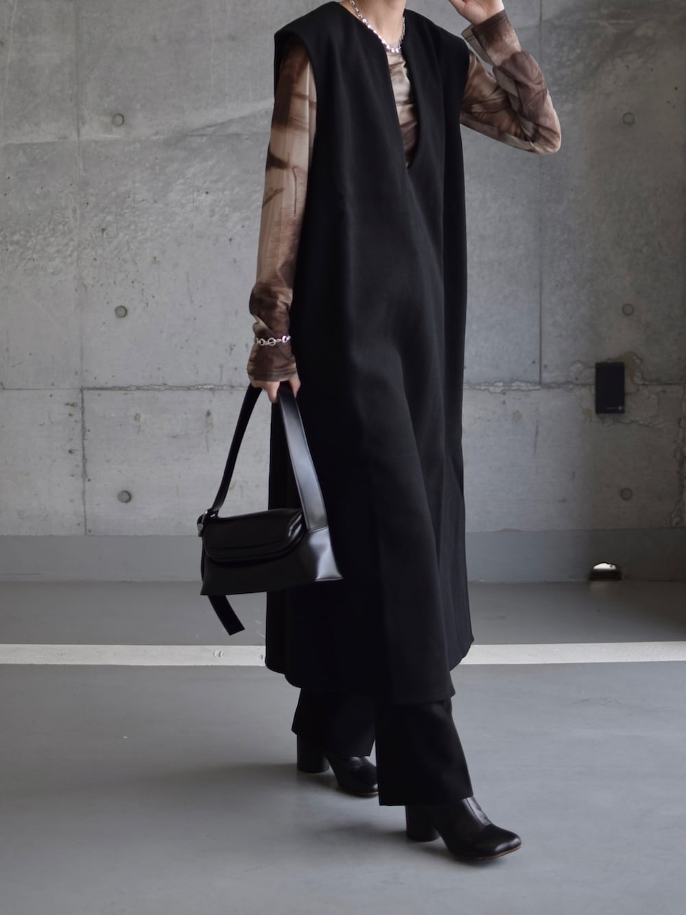 ブラウン系のTシャツ/カットソー、ブラック系のワンピース、ブラック系のショルダーバッグを着用したレディースの秋コーディネートの4枚目の写真