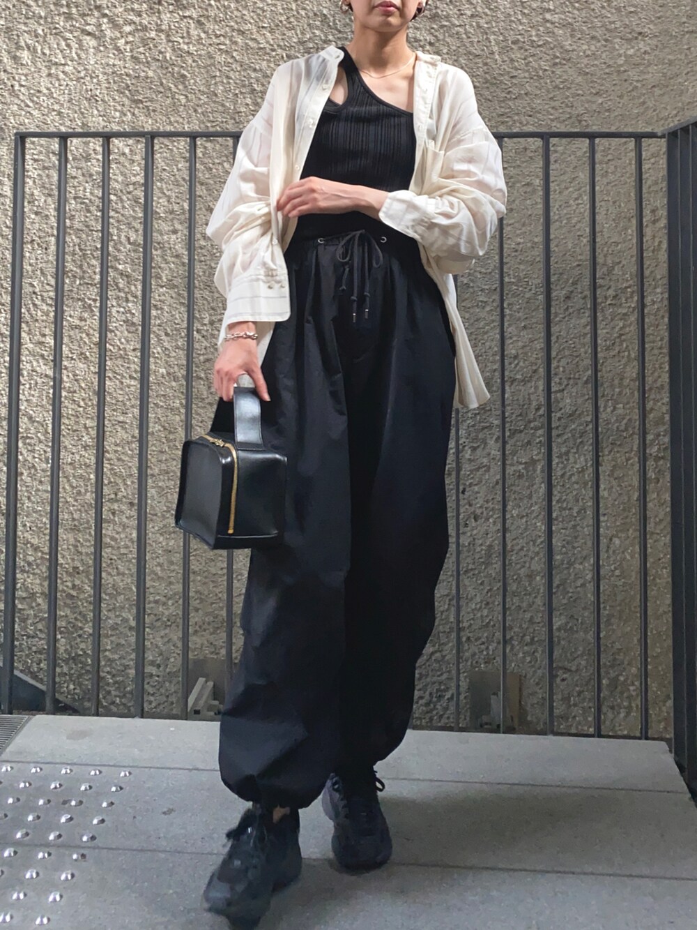 ホワイト系のシャツ/ブラウス、ブラック系のその他パンツ、ブラック系のハンドバッグを着用したレディースの夏コーディネートの2枚目の写真