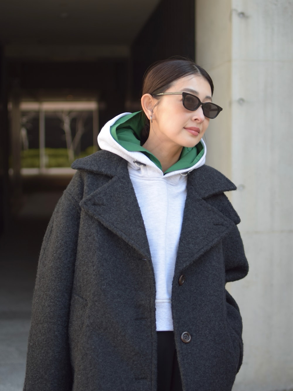 グレー系のパーカー、ブラック系のその他アウター、ブラウン系のトートバッグを着用したレディースの冬コーディネートの5枚目の写真