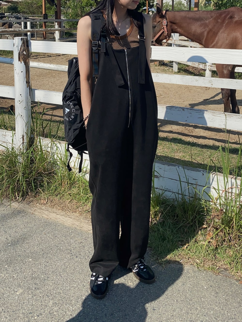ブラック系のサロペット/オーバーオール、ブラック系のバックパック/リュック、ブラック系のスニーカーを着用したレディースの夏コーディネートの4枚目の写真