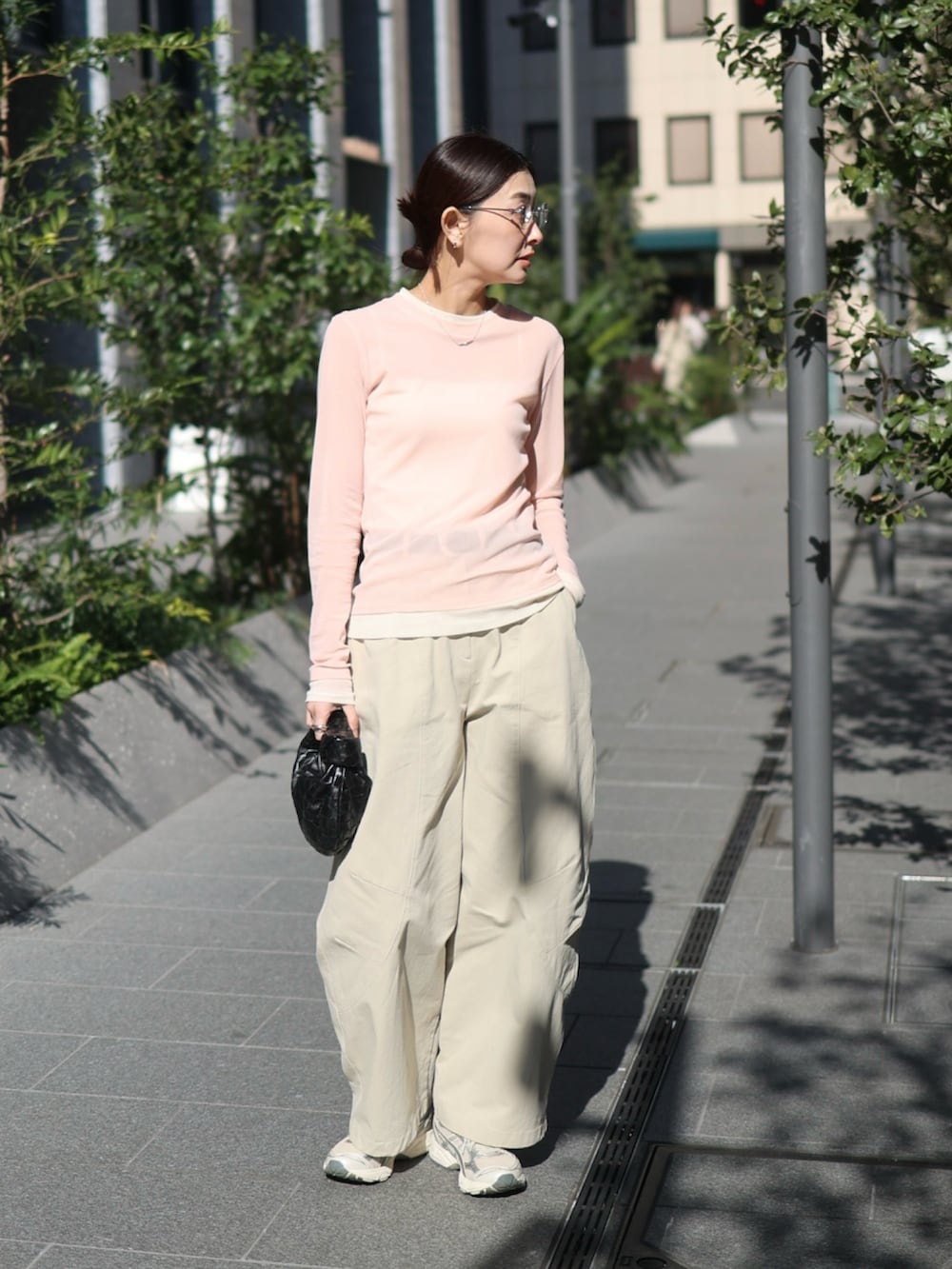 ベージュ系のチノパンツ、シルバー系のスニーカー、ピンク系のTシャツ/カットソーを着用したレディースの春コーディネートの2枚目の写真