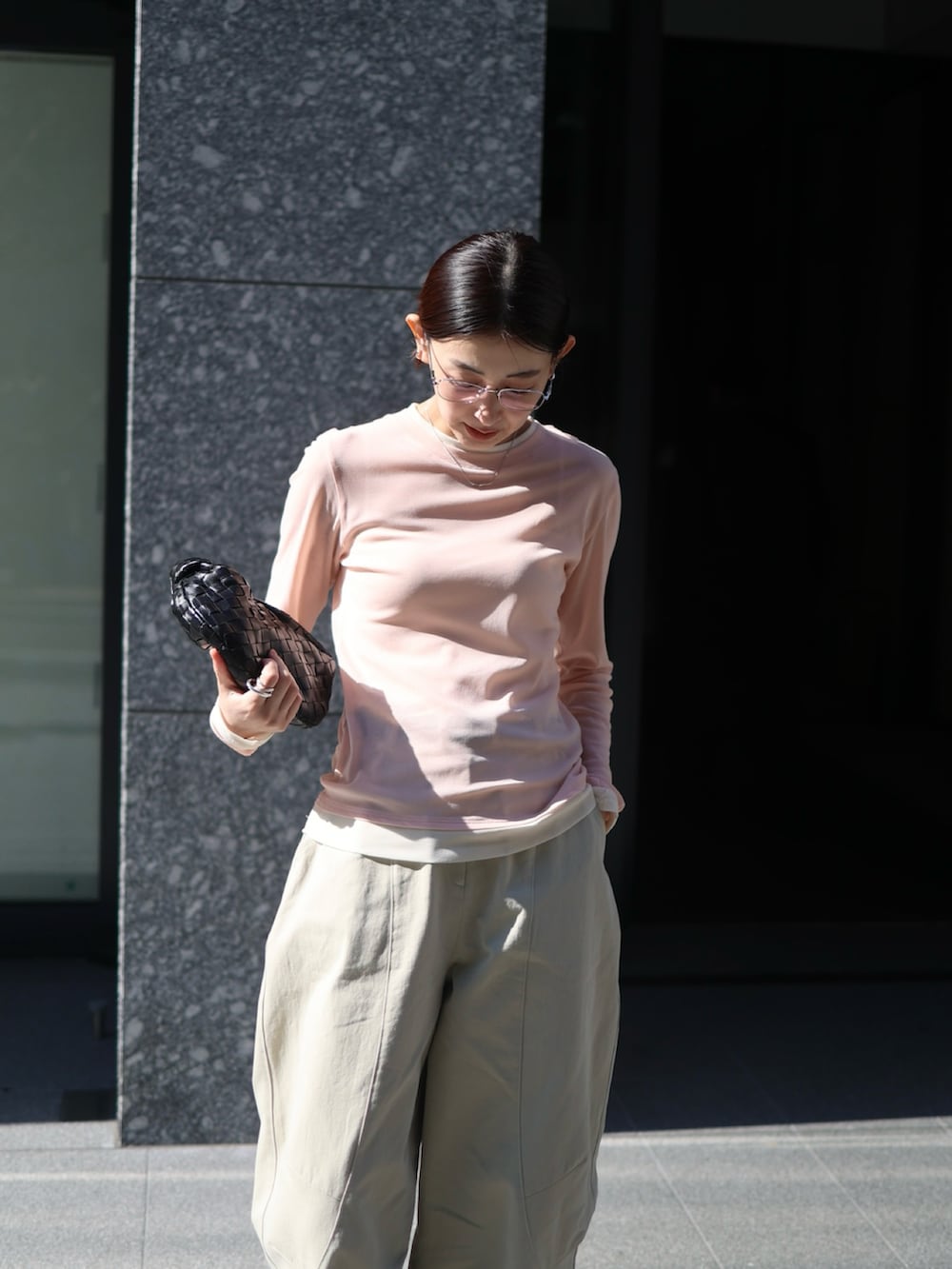 ベージュ系のチノパンツ、シルバー系のスニーカー、ピンク系のTシャツ/カットソーを着用したレディースの春コーディネートの3枚目の写真