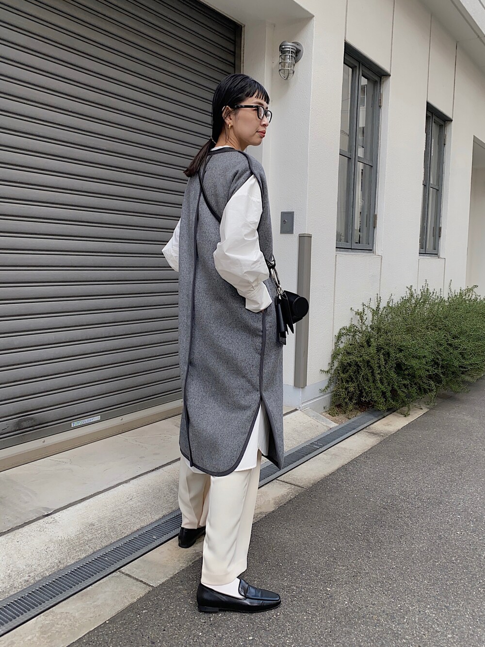 グレー系のその他アウター、ブラック系のショルダーバッグ、ブラック系のローファーを着用したレディースの冬コーディネートの2枚目の写真