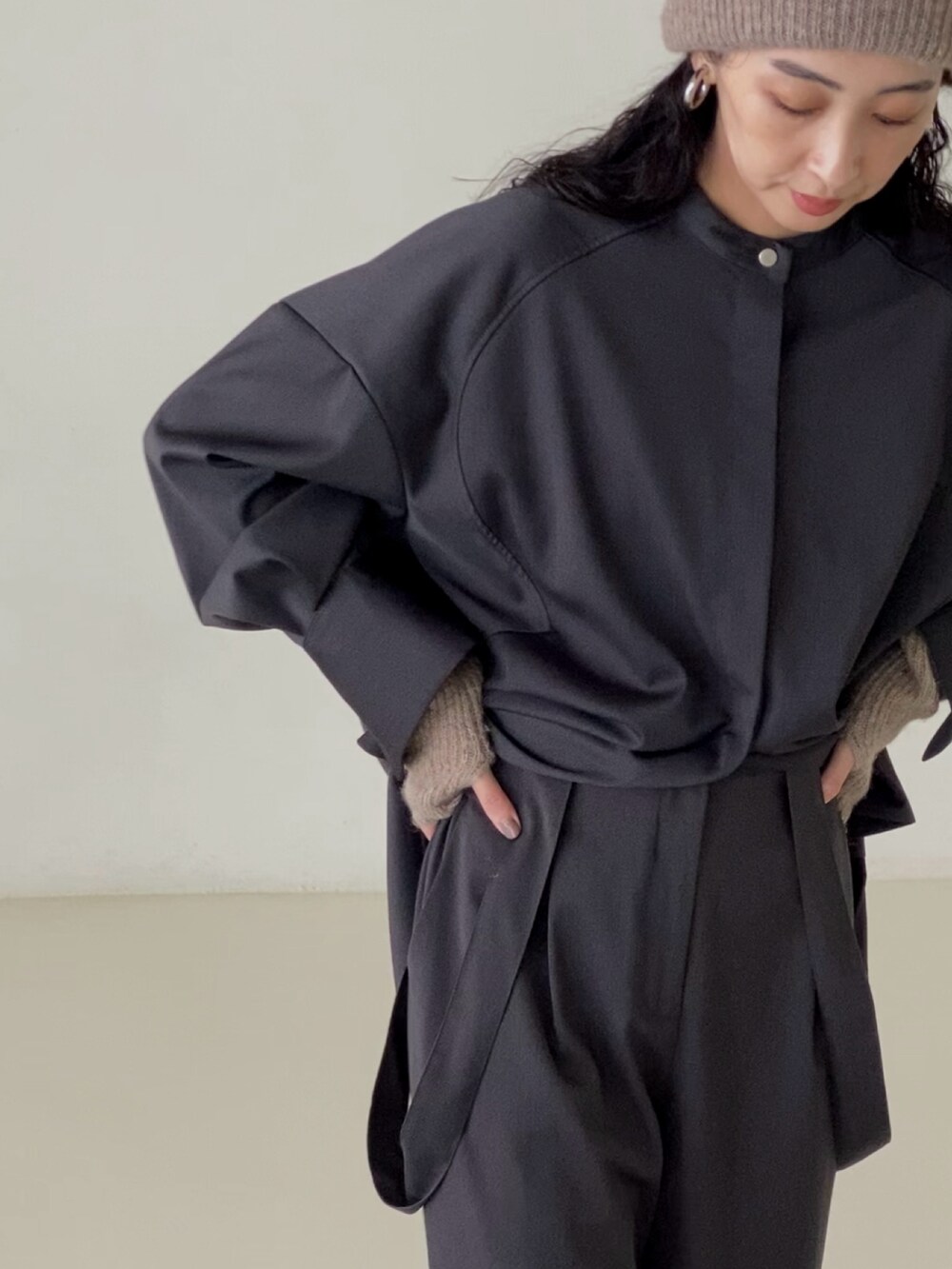 グレー系のシャツ/ブラウス、グレー系のスラックス、ベージュ系のニットキャップ/ビーニーを着用したレディースの秋コーディネートの3枚目の写真