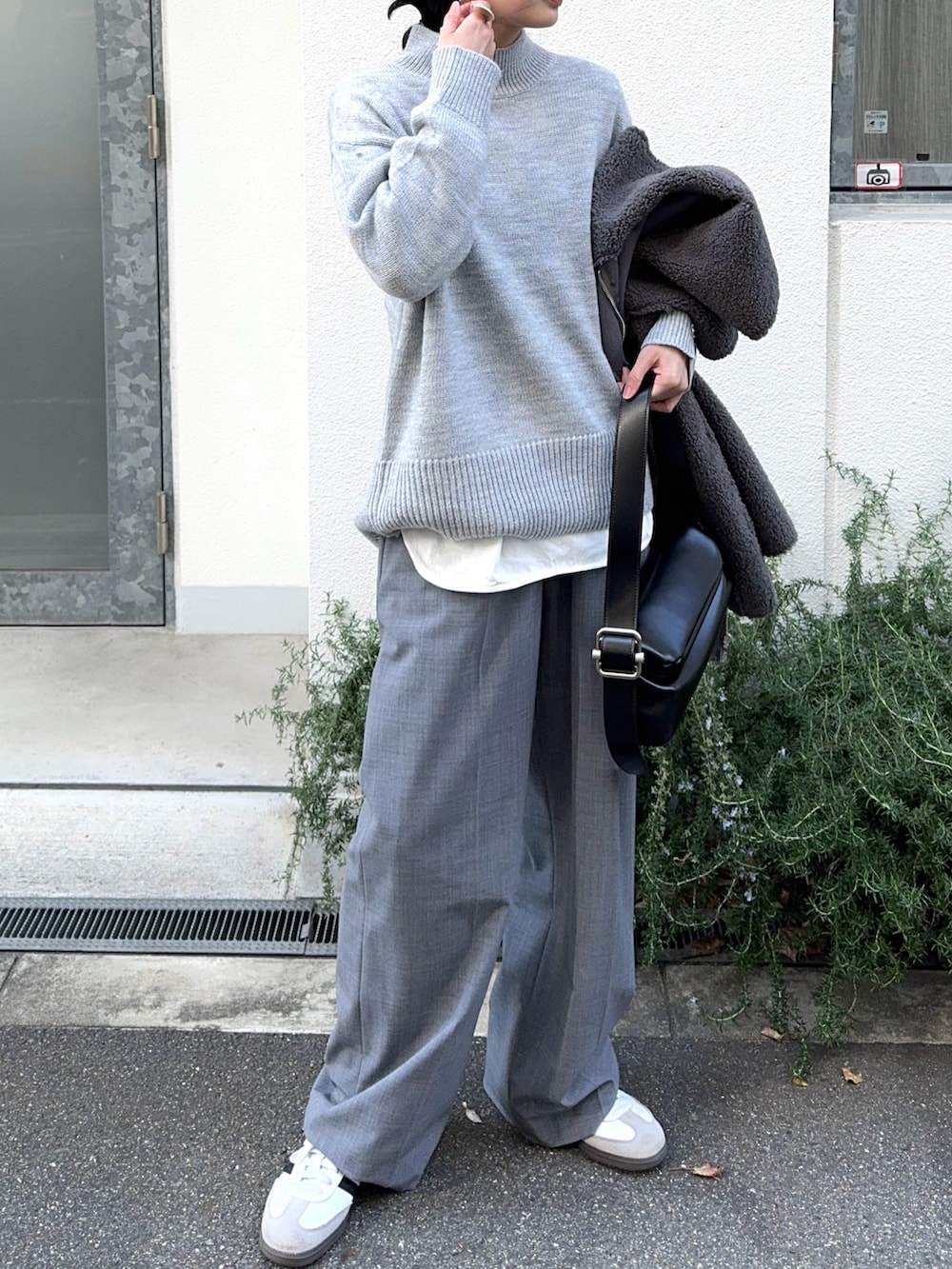 グレー系のニット/セーター、グレー系のその他アウター、ブラック系のショルダーバッグを着用したレディースの冬コーディネートの2枚目の写真