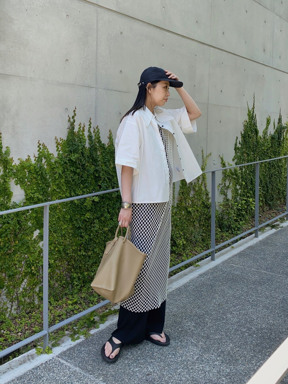 ホワイト系のシャツ/ブラウス、ホワイト系のワンピース、ベージュ系のハンドバッグを着用したレディースの夏コーディネートの2枚目の写真