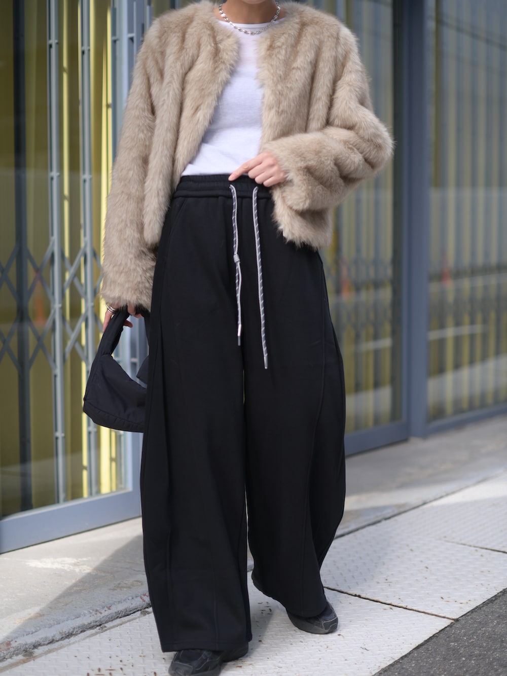 ベージュ系のその他アウター、ブラック系のスウェットパンツ、ブラック系のスニーカーを着用したレディースの冬コーディネートの4枚目の写真