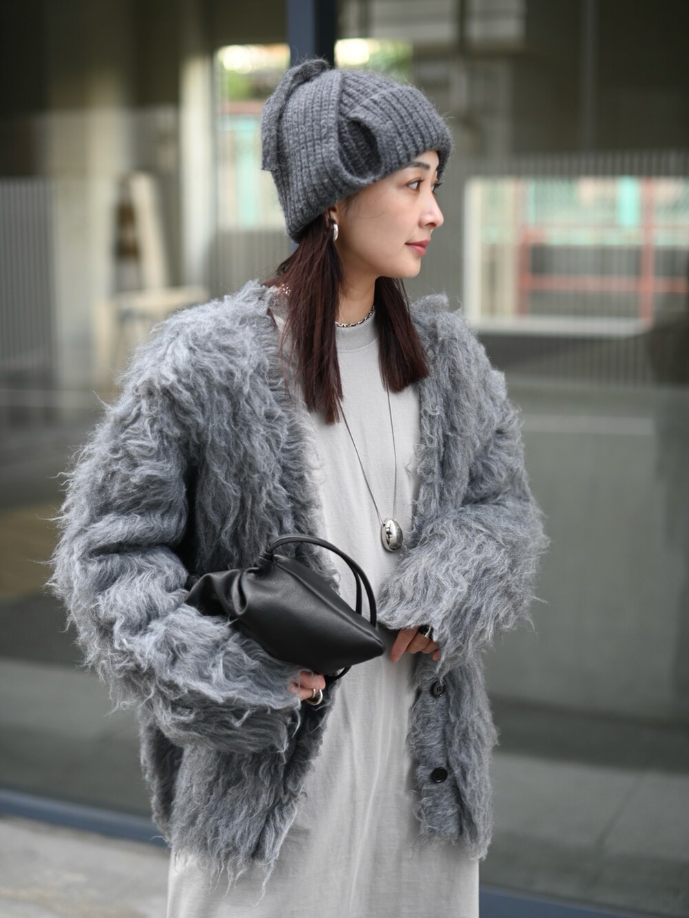グレー系のカーディガン/ボレロ、ブラック系のスラックス、グレー系のニットキャップ/ビーニーを着用したレディースの冬コーディネートの3枚目の写真