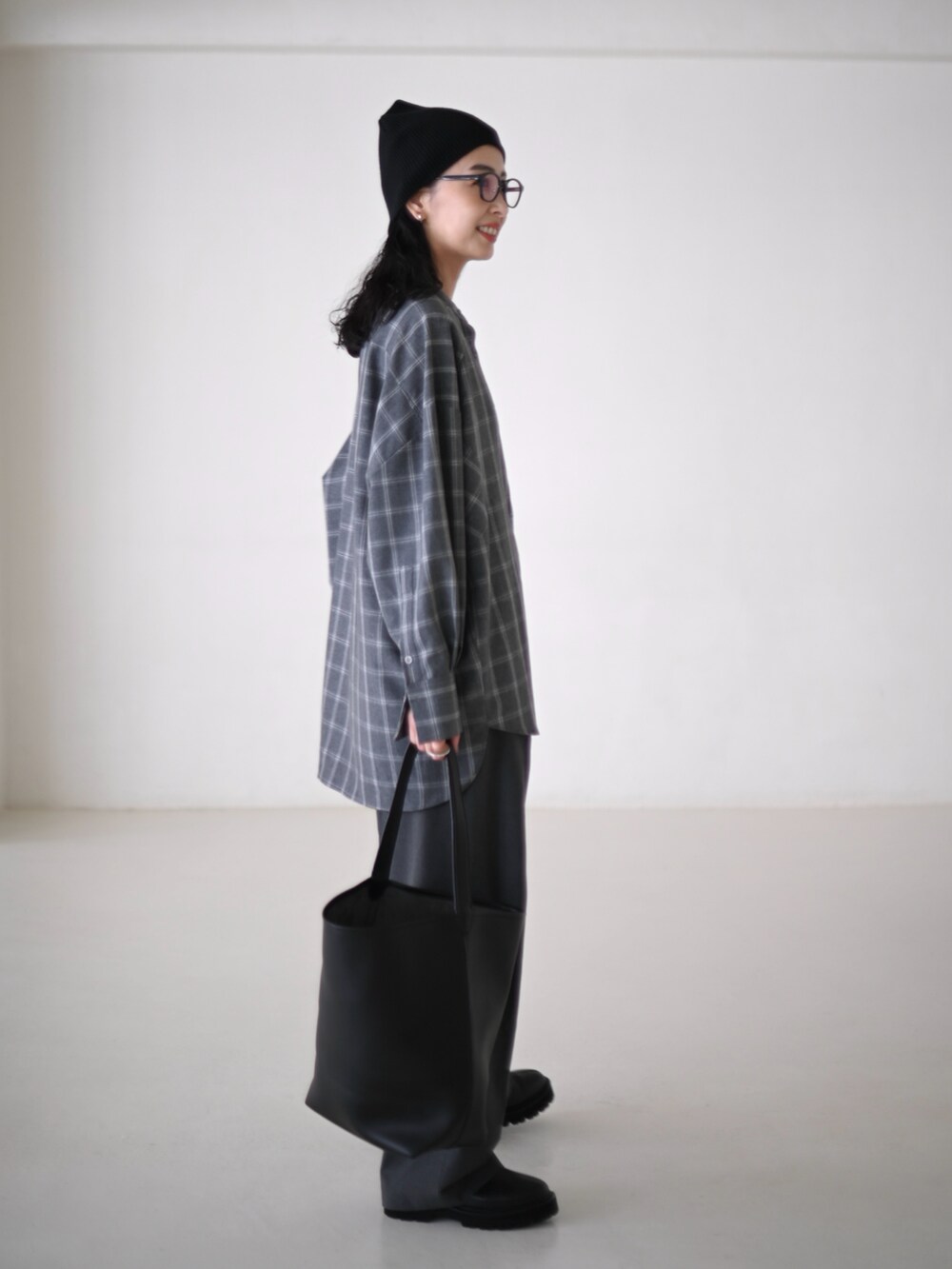 グレー系のシャツ/ブラウス、グレー系のスラックス、ブラック系のショルダーバッグを着用したレディースの秋コーディネートの3枚目の写真