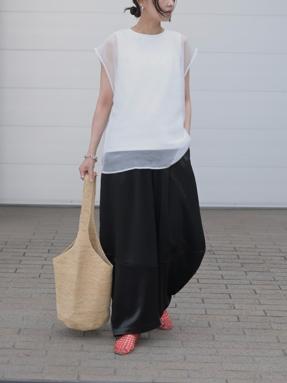 ブラック系のその他パンツ、ホワイト系のTシャツ/カットソー、ベージュ系のかごバッグを着用したレディースの夏コーディネートの3枚目の写真