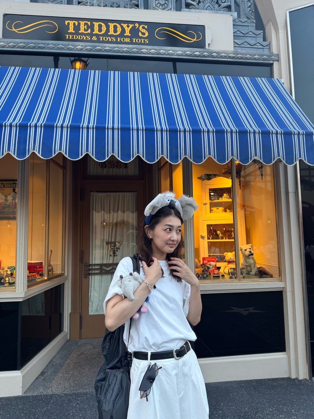 ホワイト系のTシャツ/カットソー、ホワイト系のパンツ、ブラック系のバックパック/リュックを着用したレディースの夏コーディネートの3枚目の写真