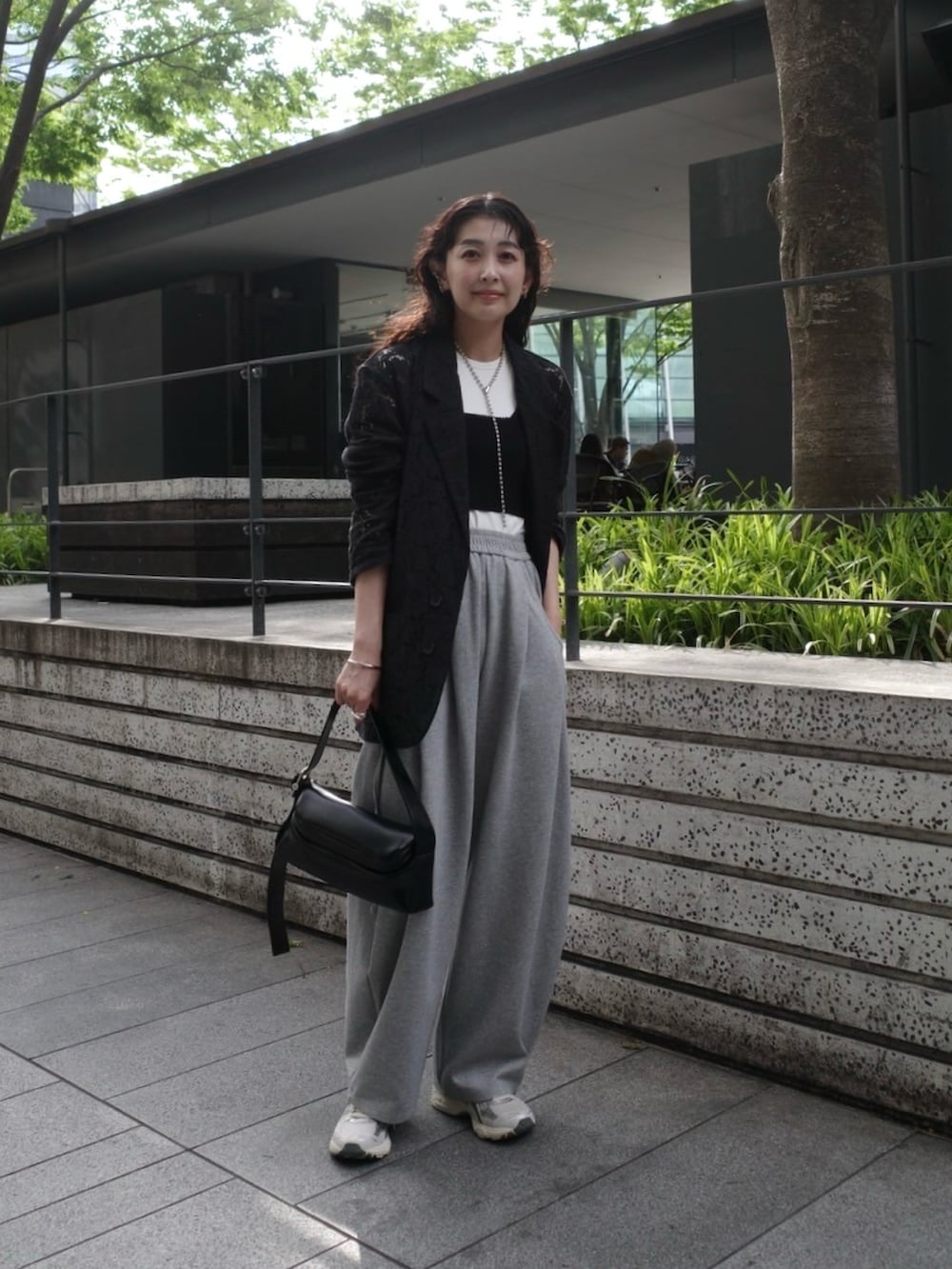 ブラック系のテーラードジャケット、ホワイト系のタンクトップ、ブラック系のタンクトップを着用したレディースの春コーディネートの3枚目の写真