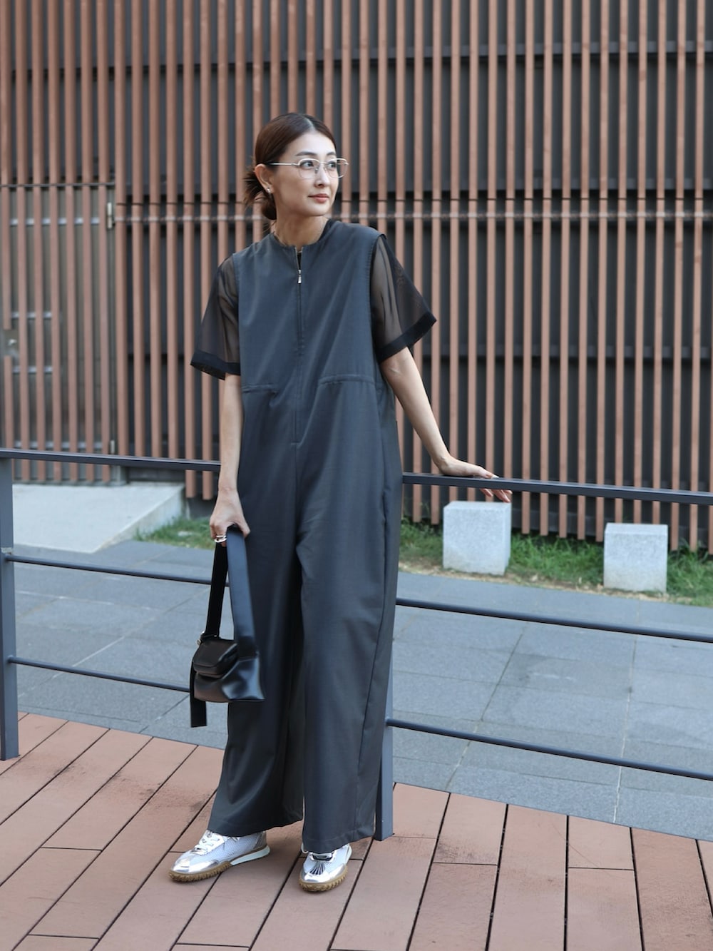 ブラック系のショルダーバッグ、シルバー系のスニーカー、グレー系のつなぎ/オールインワンを着用したレディースの秋コーディネートの2枚目の写真