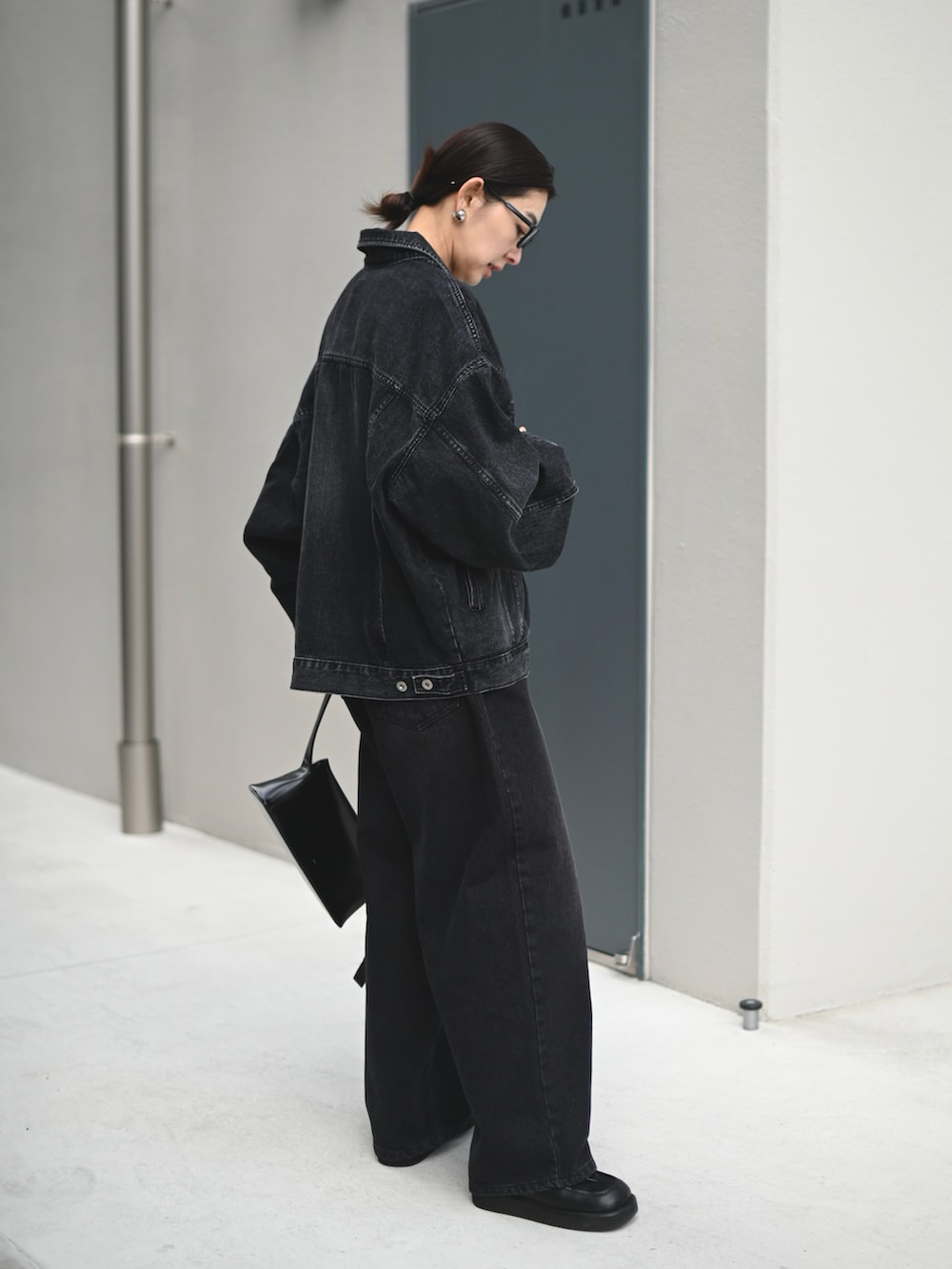 ブラック系のデニムジャケット、ブラック系のデニムパンツ、ホワイト系のTシャツ/カットソーを着用したレディースの春コーディネートの2枚目の写真