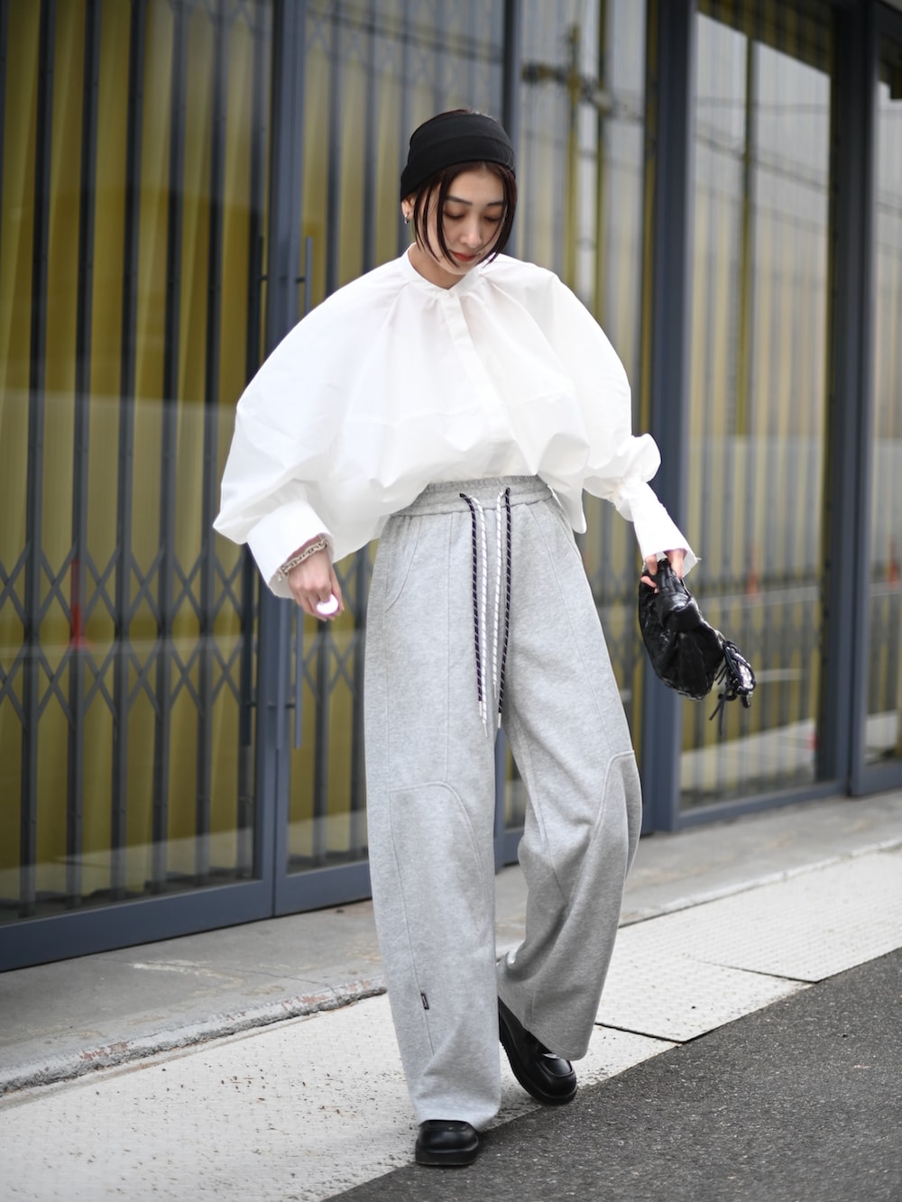 ホワイト系のシャツ/ブラウス、グレー系のスウェットパンツ、ブラック系のローファーを着用したレディースの春コーディネートの4枚目の写真