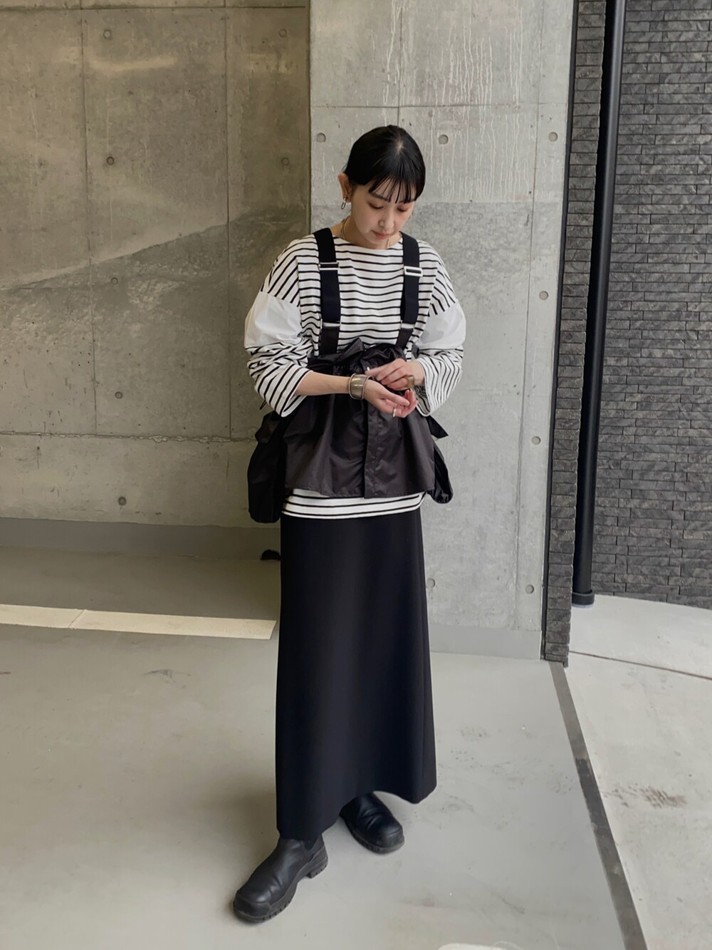 ホワイト系のTシャツ/カットソー、ブラック系のその他アウター、ブラック系のスカートを着用したレディースの春コーディネートの5枚目の写真