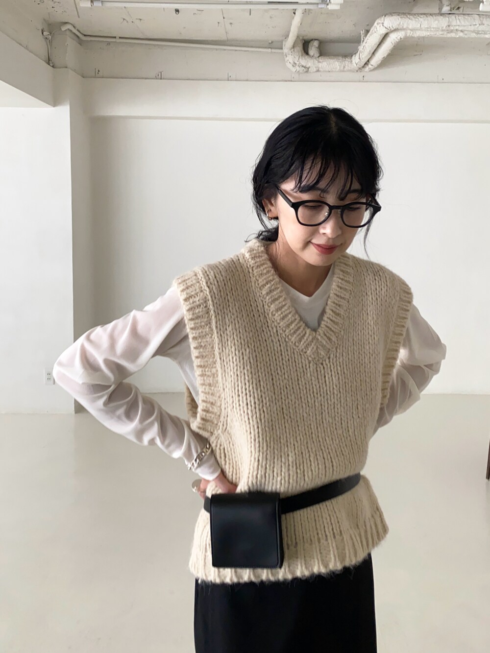 ホワイト系のベスト、ホワイト系のTシャツ/カットソー、ブラック系のスラックスを着用したレディースの冬コーディネートの4枚目の写真