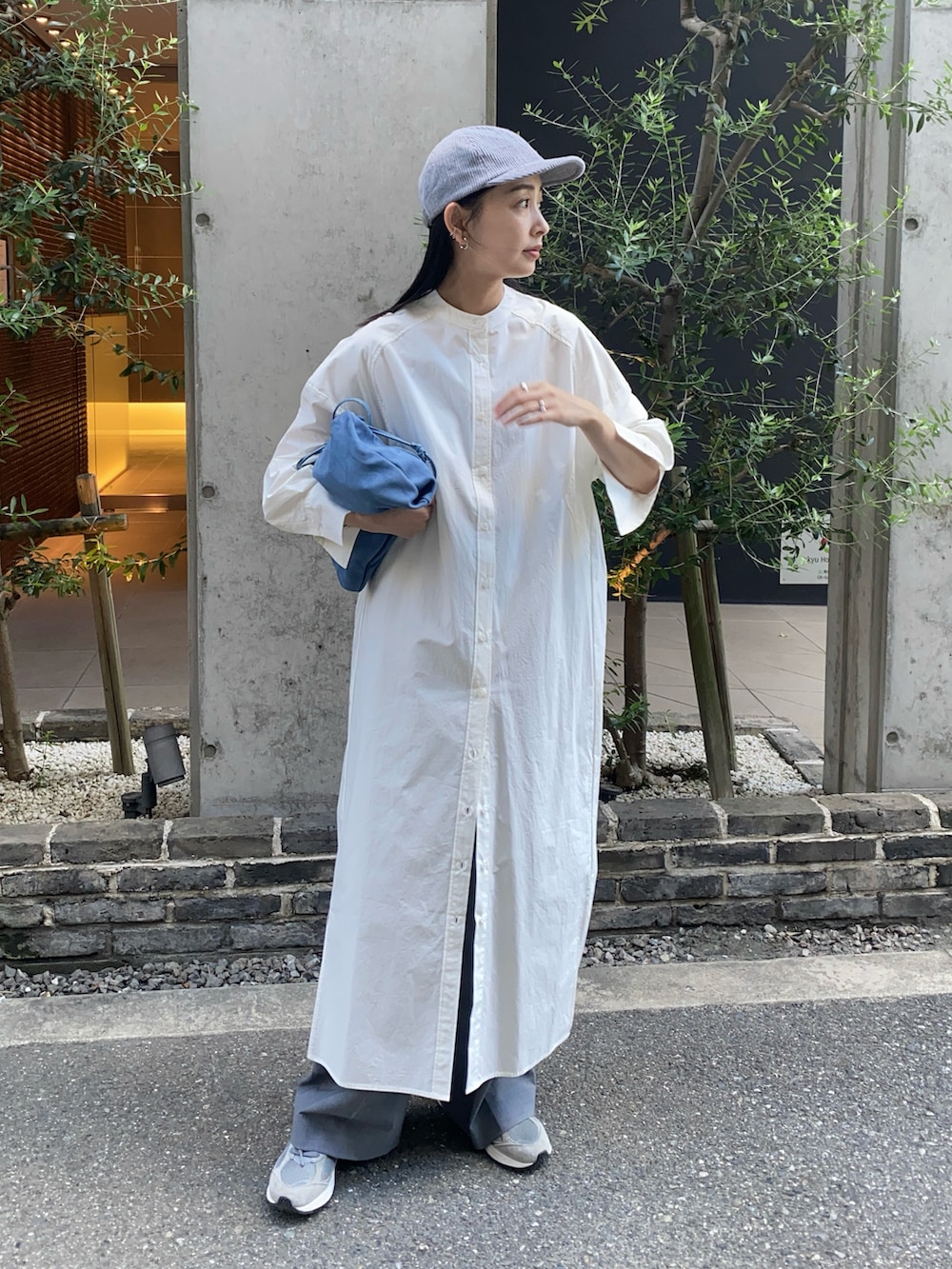 ホワイト系のシャツワンピース、グレー系のスラックス、グレー系のスニーカーを着用したレディースの秋コーディネートの3枚目の写真