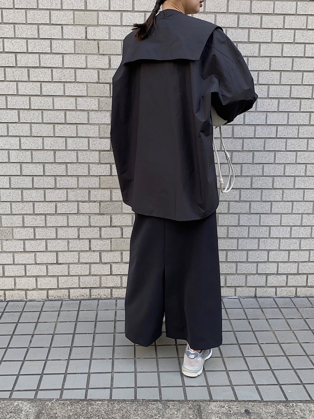 ブラック系のシャツ/ブラウス、グレー系のスニーカー、ホワイト系のショルダーバッグを着用したレディースの冬コーディネートの3枚目の写真