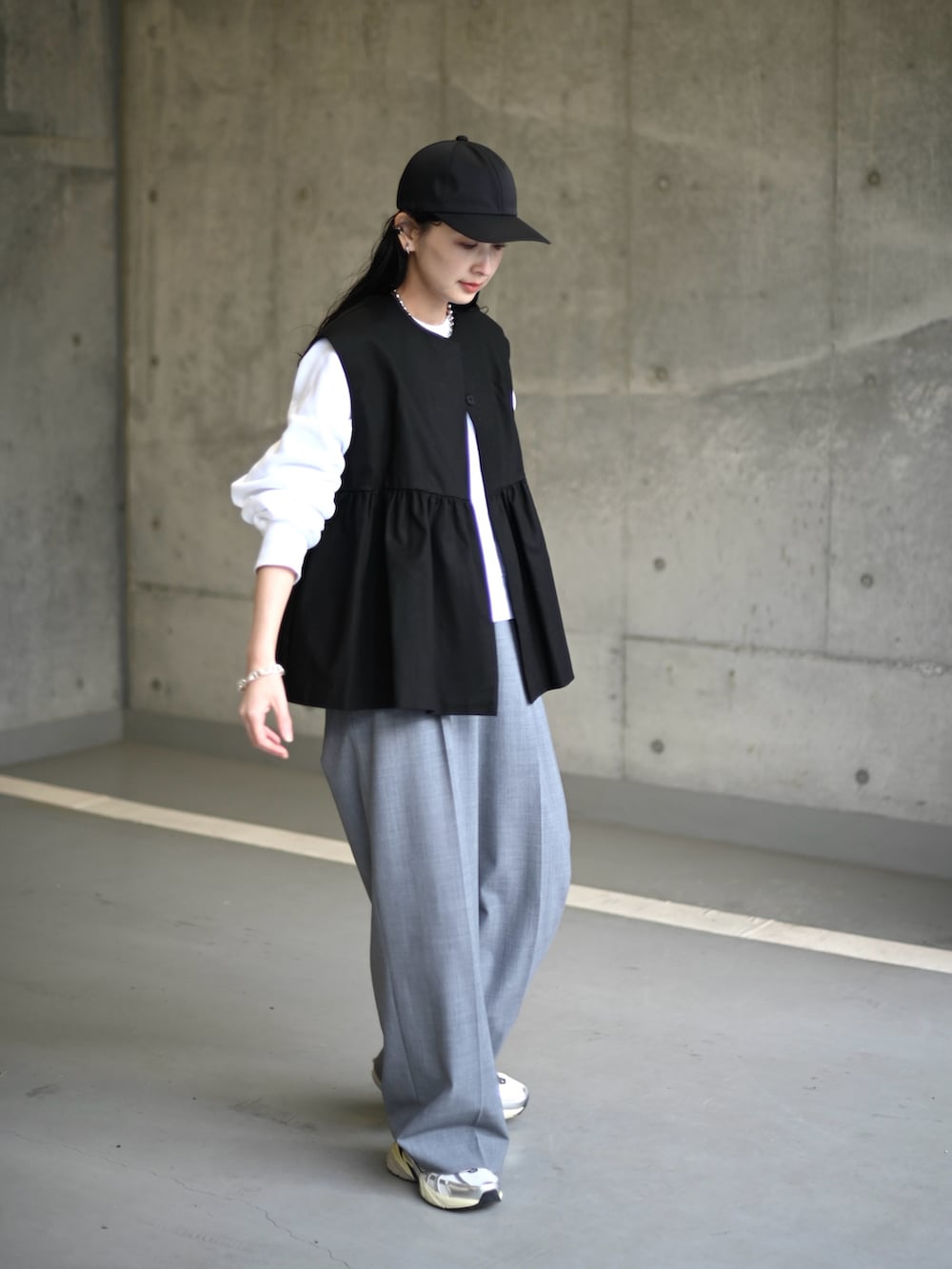 ブラック系のその他アウター、グレー系のスラックス、ホワイト系のスニーカーを着用したレディースの冬コーディネートの3枚目の写真