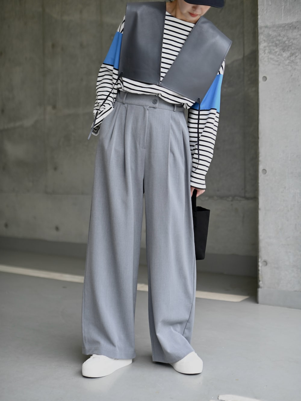 ブルー系のTシャツ/カットソー、グレー系のベスト、グレー系のスラックスを着用したレディースの春コーディネートの4枚目の写真