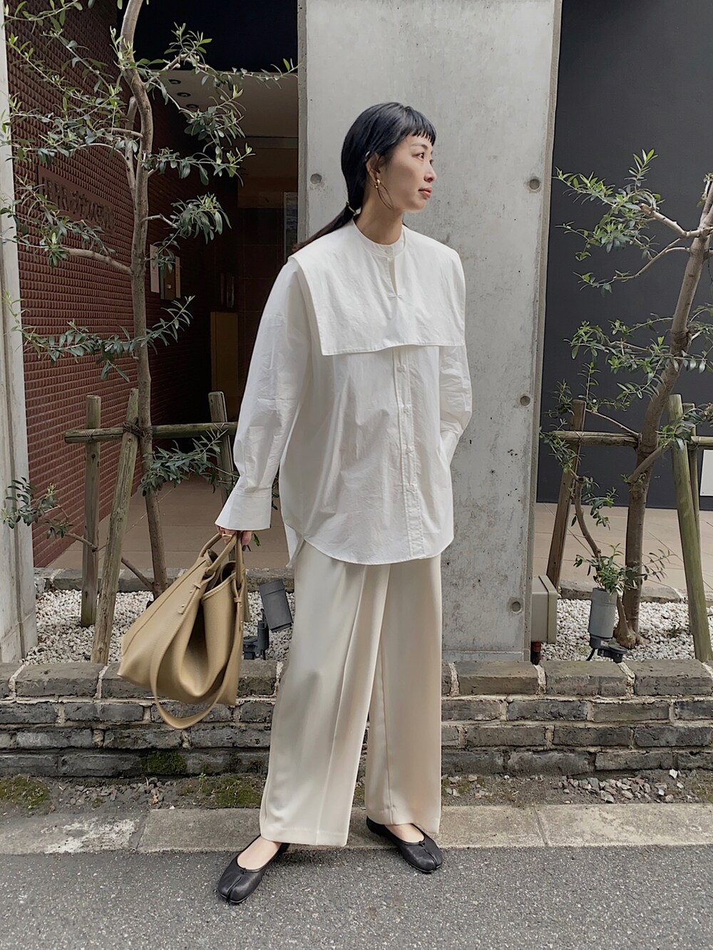 ホワイト系のシャツ/ブラウス、ベージュ系のハンドバッグ、ブラック系のバレエシューズを着用したレディースの冬コーディネートの3枚目の写真