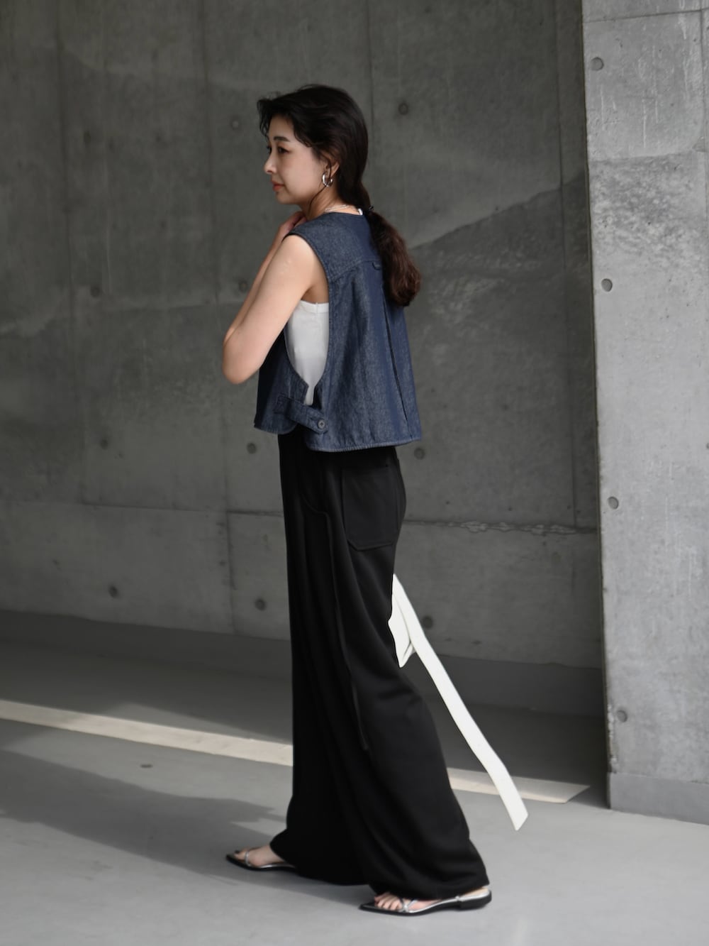 ブルー系のベスト、ブラック系のスウェットパンツ、シルバー系のサンダルを着用したレディースの夏コーディネートの3枚目の写真