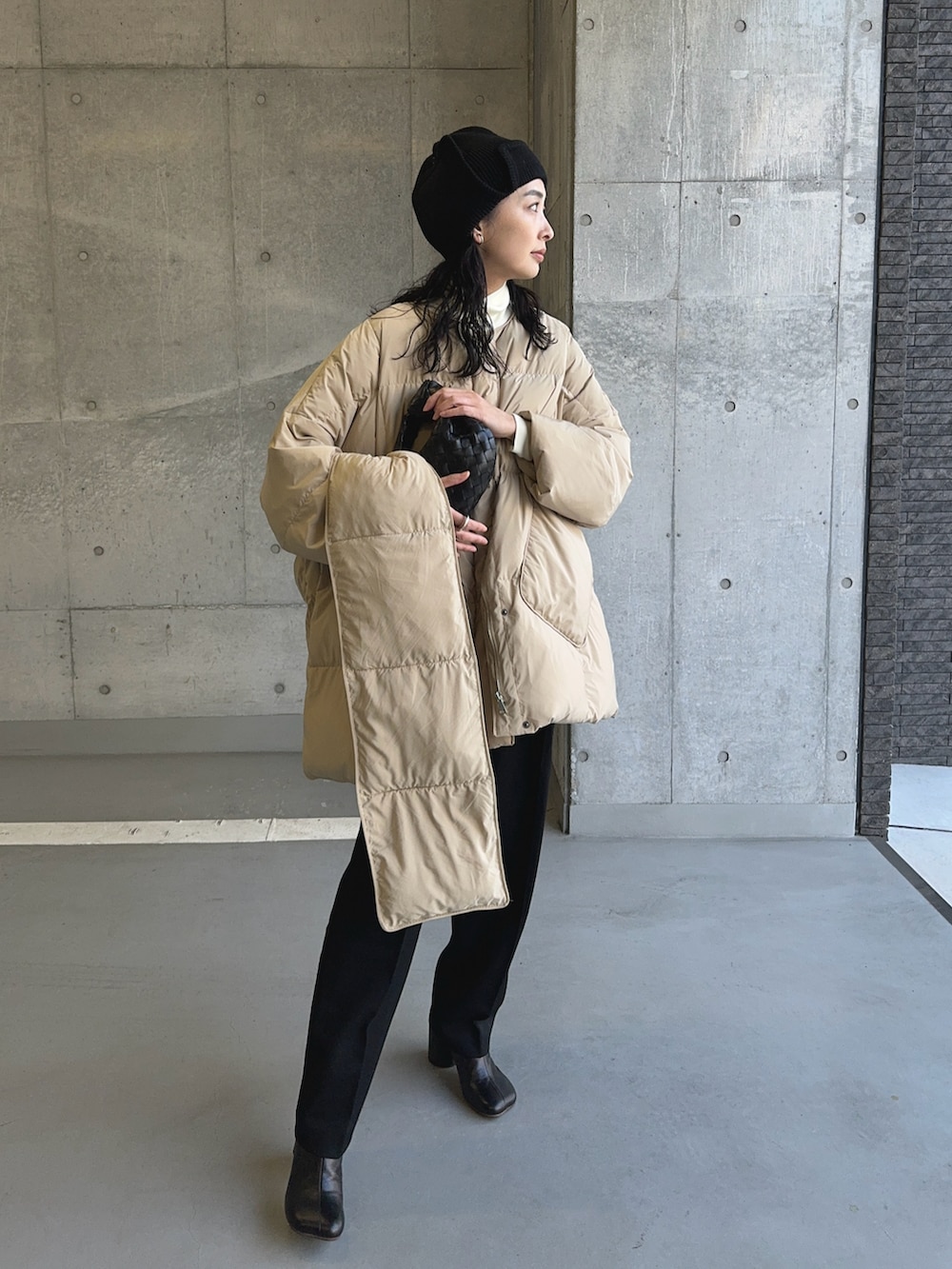 ベージュ系のダウンジャケット/コート、ブラック系のブーツ、ブラック系のハットを着用したレディースの冬コーディネートの4枚目の写真