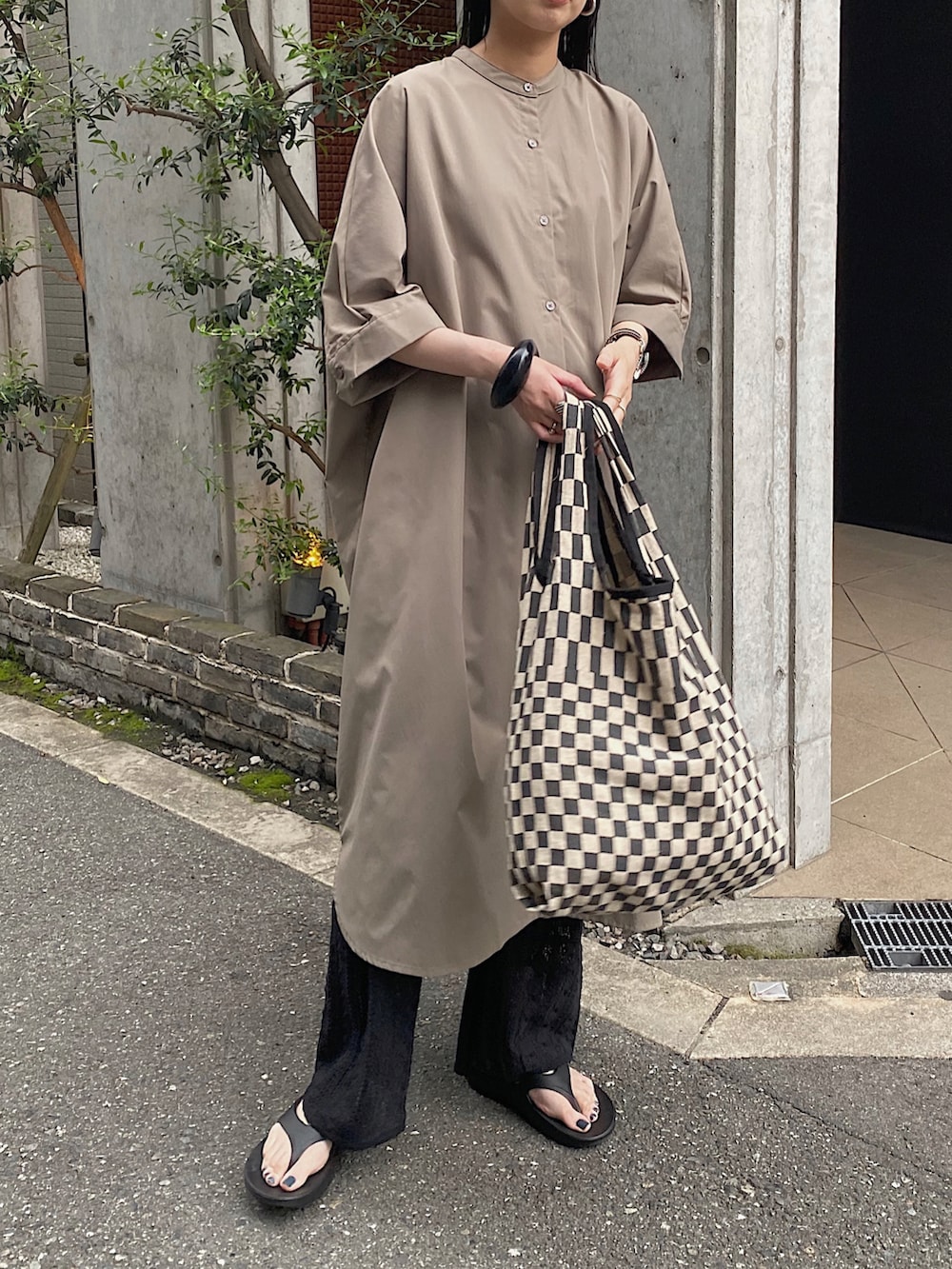 グリーン系のシャツワンピース、ブラック系のその他パンツ、ブラック系のトートバッグを着用したレディースの春コーディネートの3枚目の写真