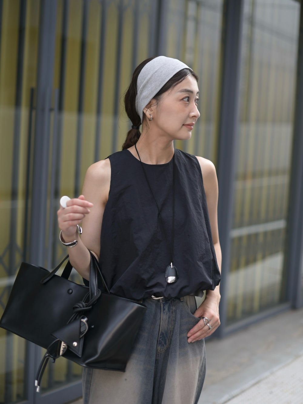 ブルー系のデニムパンツ、ブラック系のシャツ/ブラウス、ブラック系のトートバッグを着用したレディースの夏コーディネートの3枚目の写真