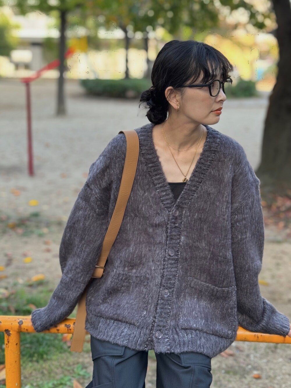 グレー系のカーディガン/ボレロ、ブラウン系のショルダーバッグ、グリーン系のカーゴパンツを着用したレディースの冬コーディネートの4枚目の写真