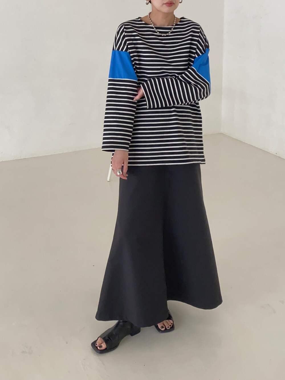 ブルー系のTシャツ/カットソー、ブラック系のスカートを着用したレディースの春コーディネートの2枚目の写真