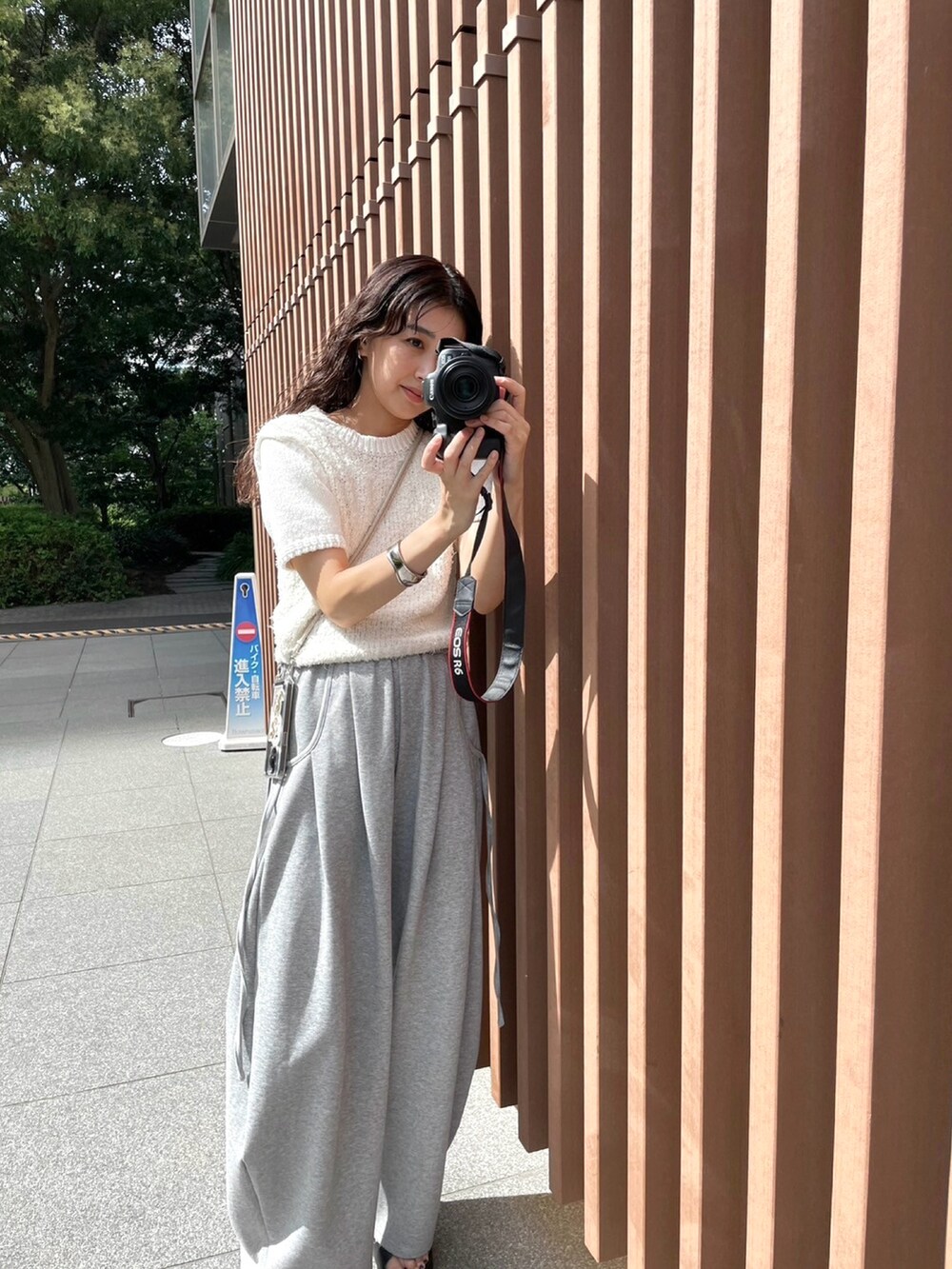 グレー系のスウェットパンツ、ホワイト系のニット/セーター、ブラック系のサンダルを着用したレディースの夏コーディネートの5枚目の写真