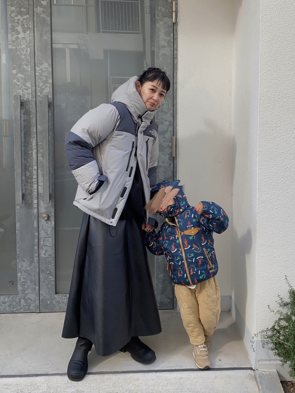 グレー系のその他アウター、ブラック系のスカートを着用したレディースの冬コーディネートの2枚目の写真