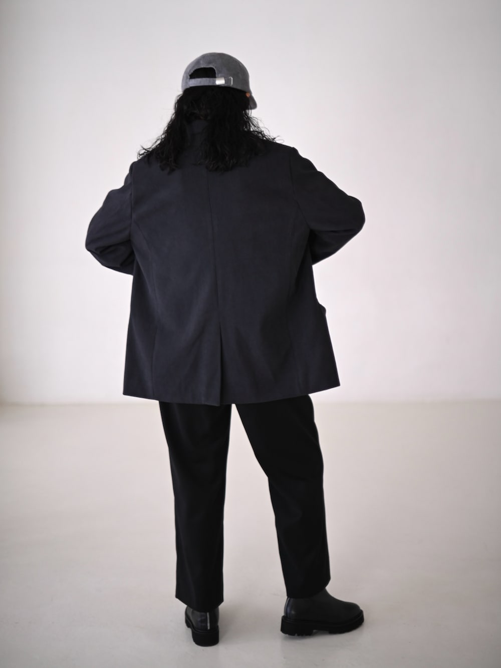 グレー系のテーラードジャケット、ブラック系のスラックス、グレー系のシャツ/ブラウスを着用したレディースの冬コーディネートの4枚目の写真