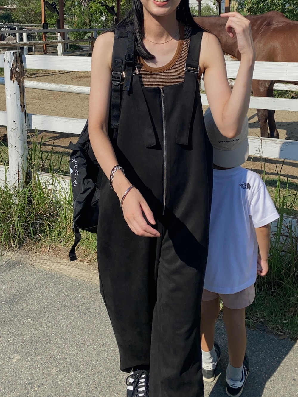 ブラック系のサロペット/オーバーオール、ブラック系のバックパック/リュック、ブラック系のスニーカーを着用したレディースの夏コーディネートの2枚目の写真