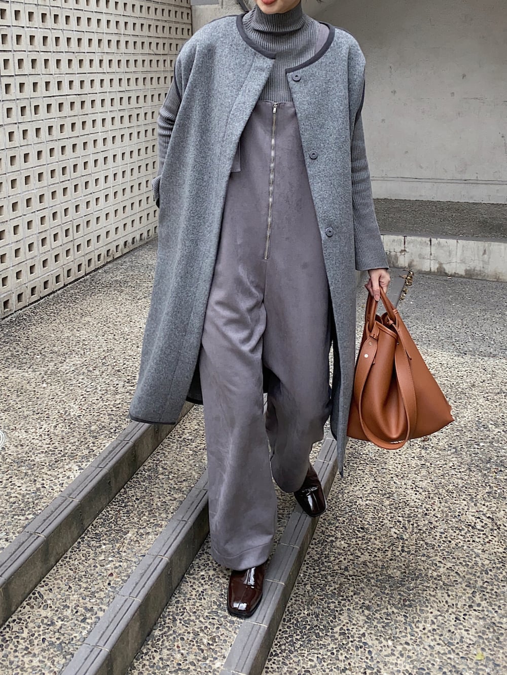 グレー系のその他アウター、グレー系のサロペット/オーバーオール、ブラック系のニット/セーターを着用したレディースの冬コーディネートの2枚目の写真